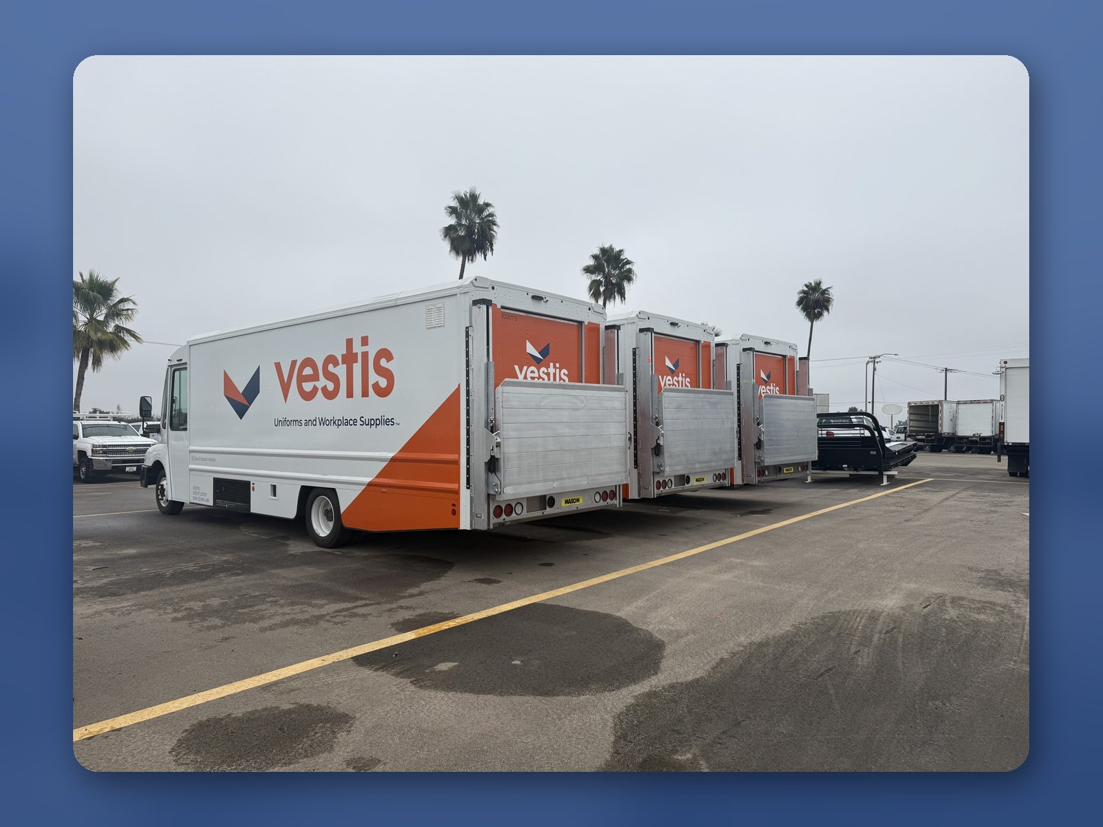Two Workhorse W56 step vans in a customer's orange-and-white livery at a loading dock.
