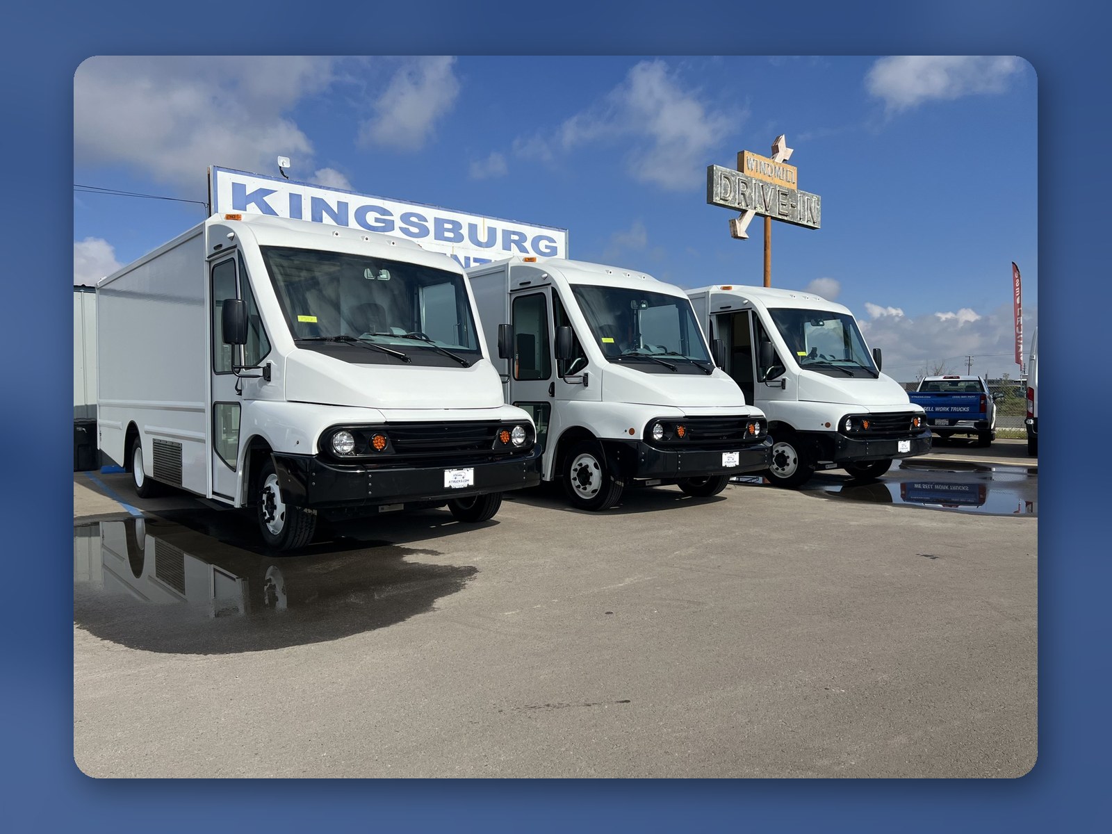 Three Workhorse W56 step vans parked beneath the Kingsburg sign at the dealership.