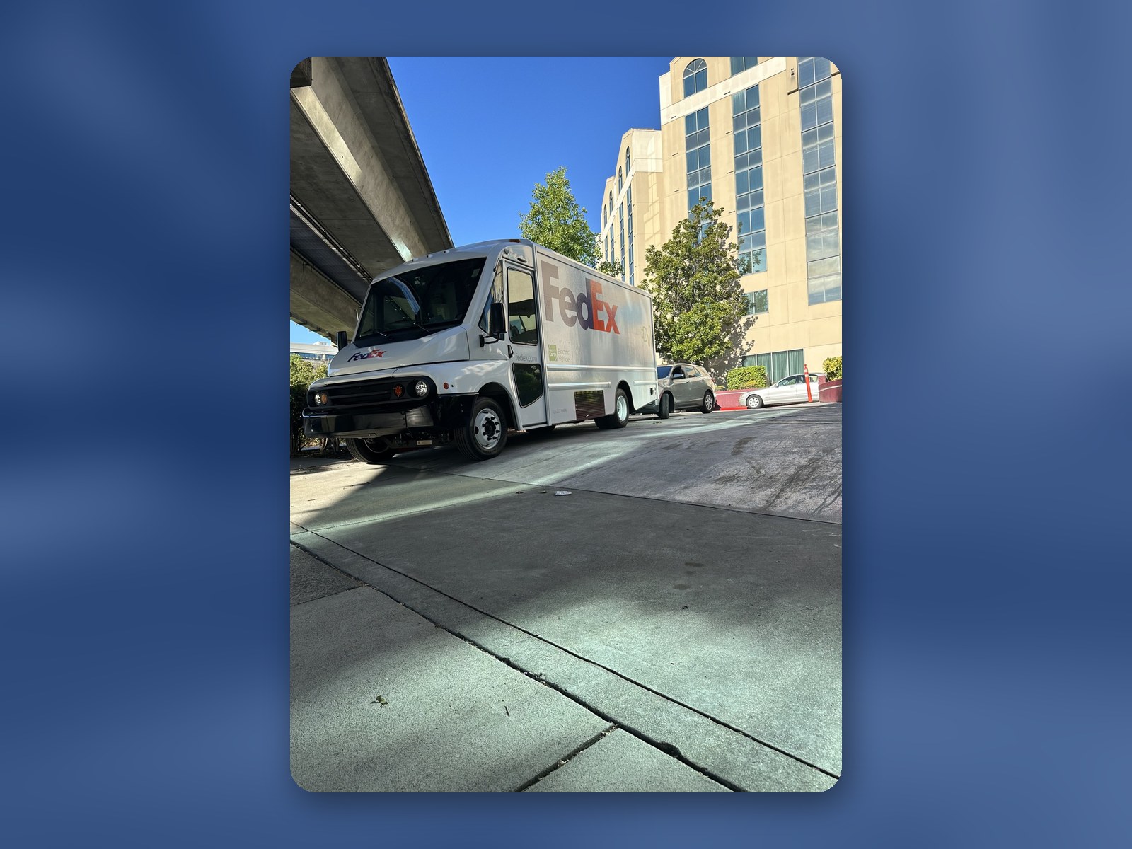 A Workhorse W56 electric step van making a delivery stop on a city street.