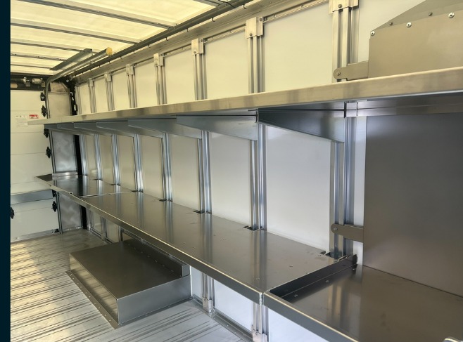 Package C Fixed Top / Folding Bottom shelving in a Workhorse W56 step van, side view of fixed upper shelves above a folding lower tier.