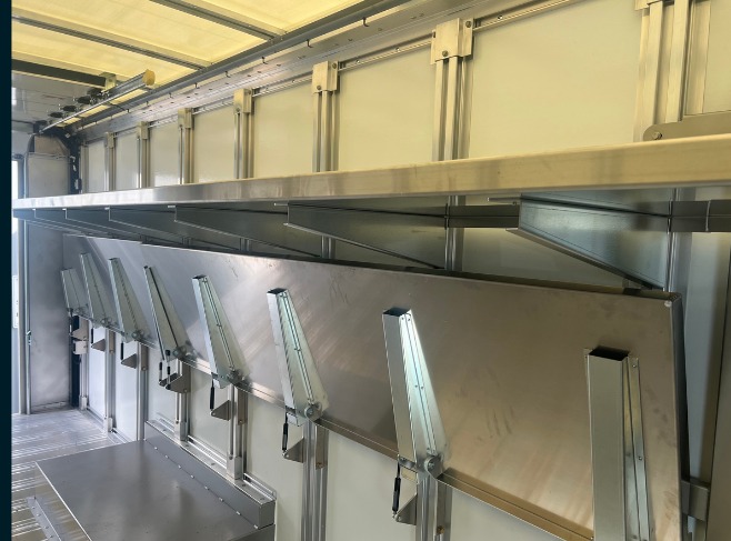 Package C Fixed Top / Folding Bottom shelving in a Workhorse W56 step van, close-up of folding lower shelves stowed beneath the fixed top shelf.