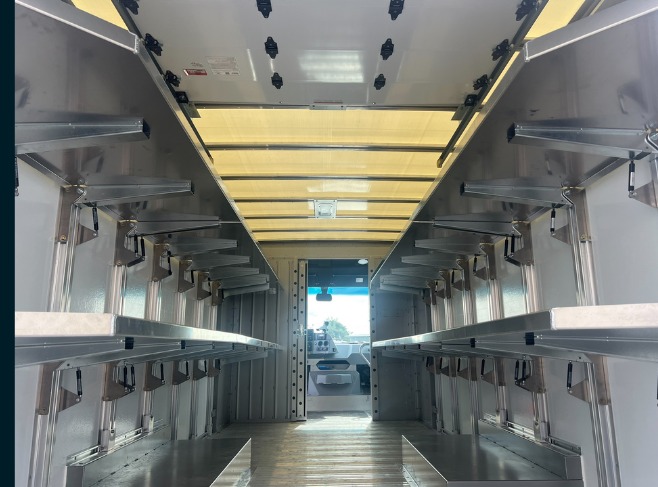 Package B All Folding shelving in a Workhorse W56 step van, folding shelves deployed level on both walls with gas struts visible.