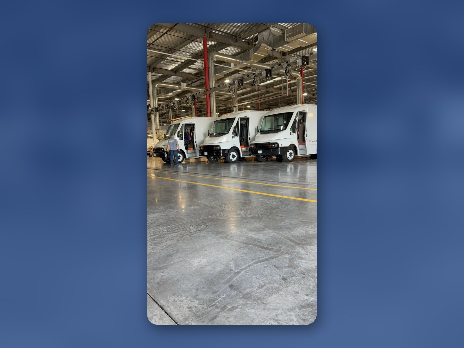Several Workhorse W56 step vans inside a large upfit and fabrication shop.
