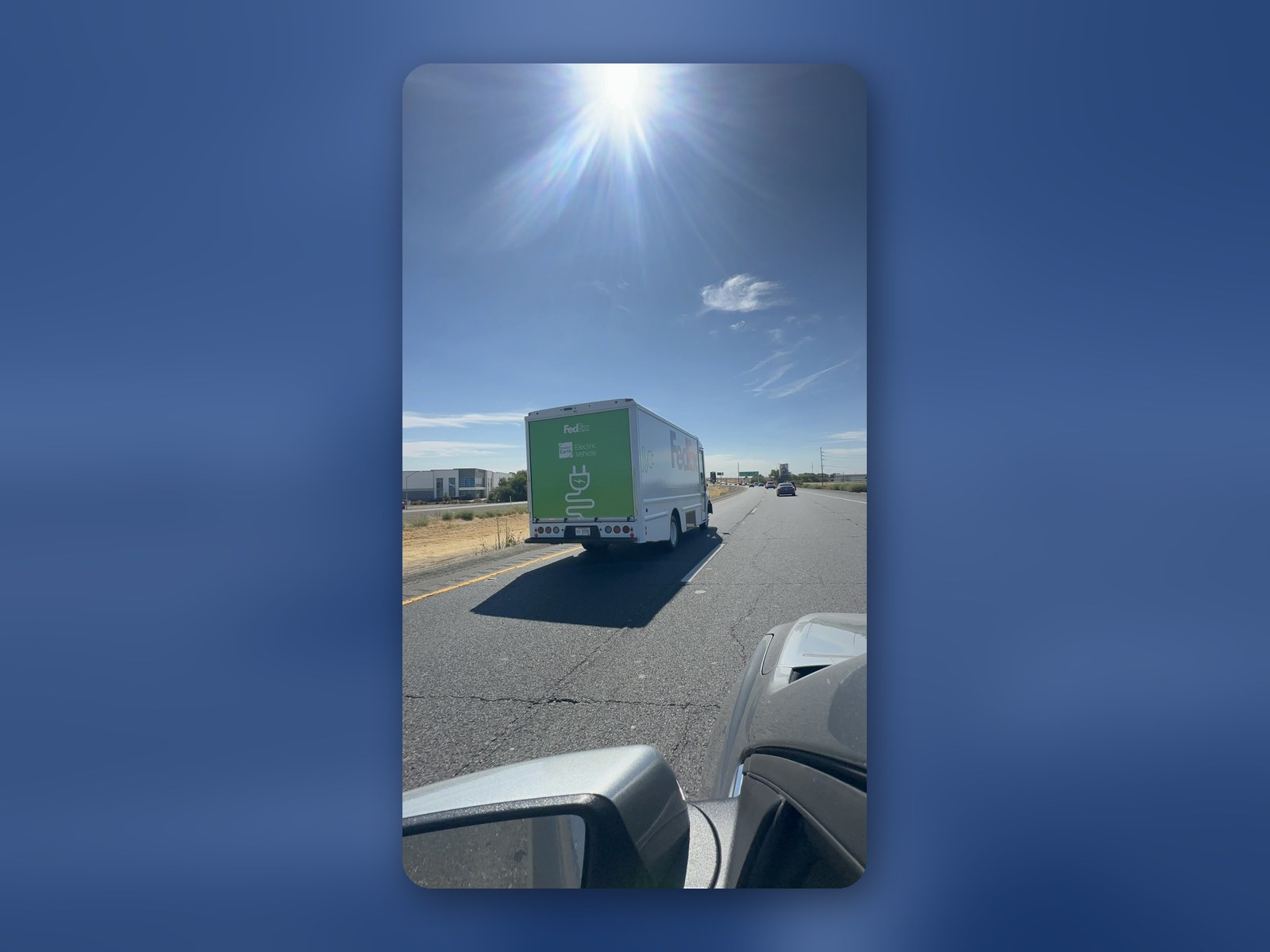 A Workhorse W56 step van traveling down a rural highway, seen through a windshield.