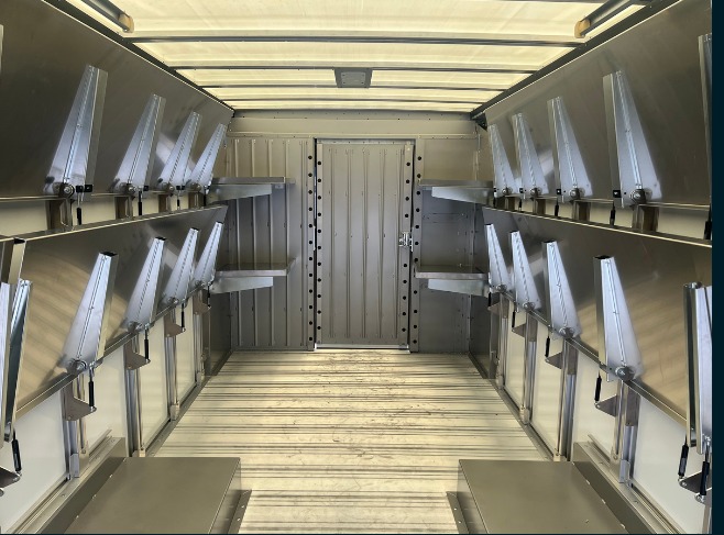 Package B All Folding shelving in a Workhorse W56 step van, shelves folded flat against the wall clearing the full cargo floor.