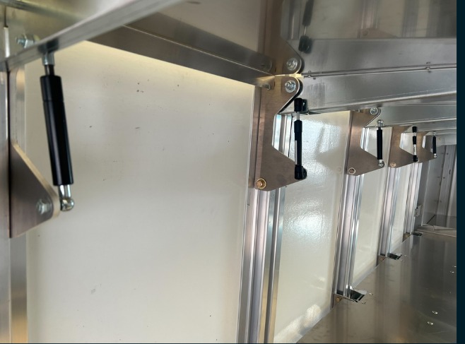 Package B All Folding shelving in a Workhorse W56 step van, close-up of the gas strut and hinge hardware supporting a folding shelf.