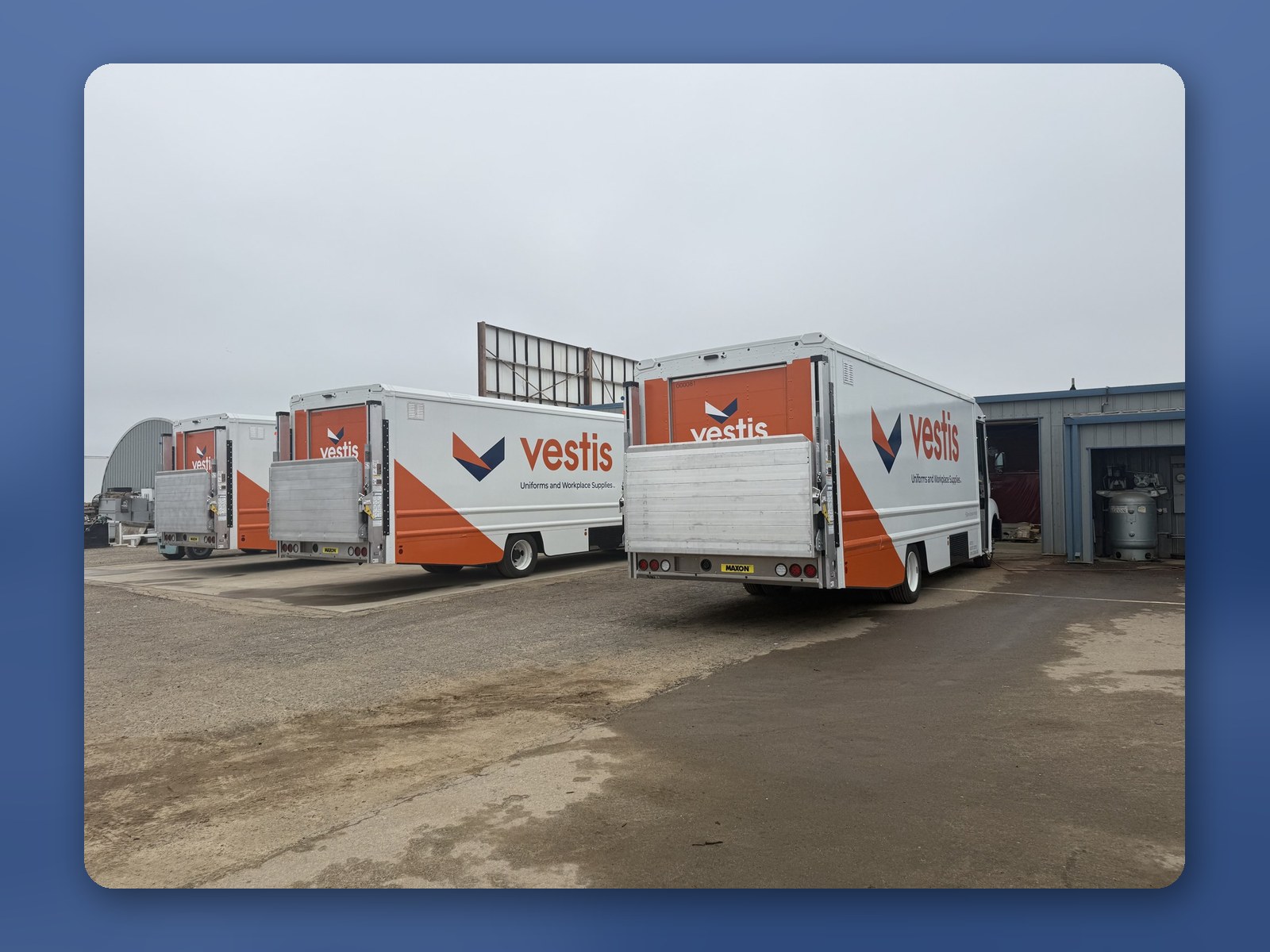 Workhorse W56 step vans parked in front of a customer's warehouse with palm trees behind.
