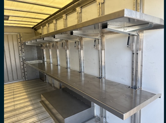 Package D Fixed Front / Folding Rear shelving in a Workhorse W56 step van, fixed forward shelves deployed along the curb side.