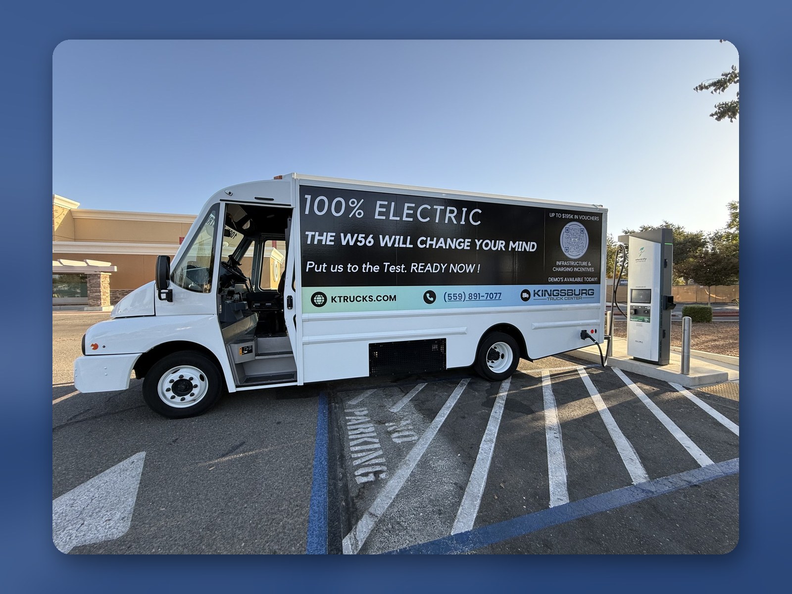 A Workhorse W56 electric step van charging at a DC fast charger, with 100% Electric lettering on the side.