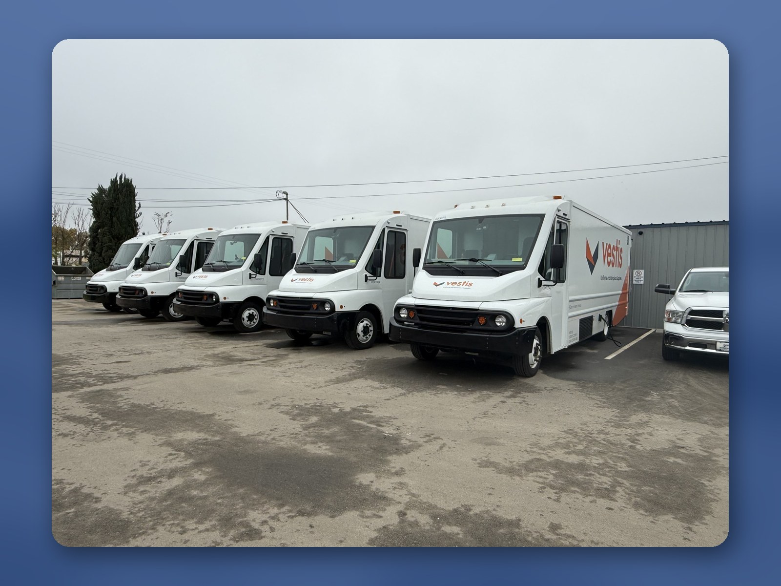 A row of white Workhorse W56 step vans parked at a customer facility.
